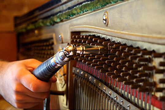 close up view of tuning the mid-range of a piano.